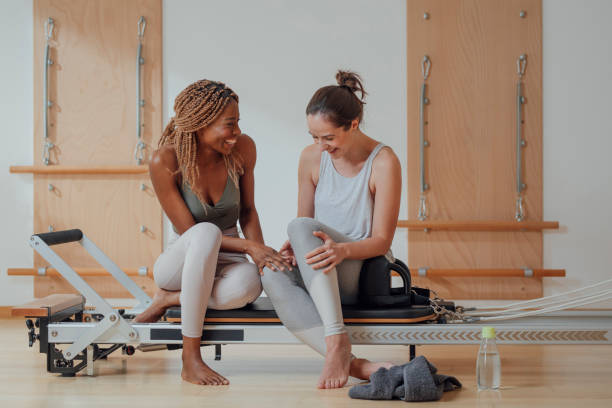 istock Two Women Sitting on Pilates Reformer 1201708200