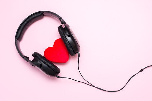 Headphones and heart on pink background, love music concept