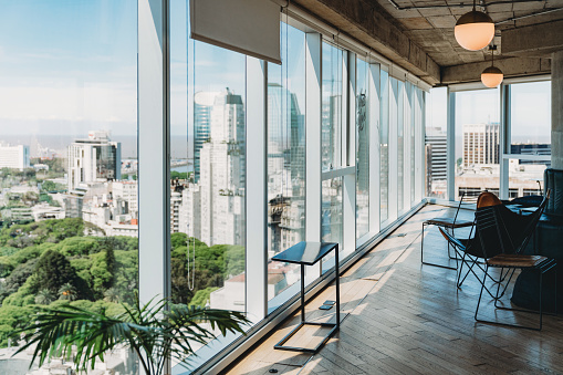 Modern office with big windows in Buenos Aires. No people. City's skyline outside of the window.