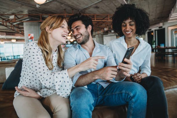 istock Three colleagues looking at a smartphone together during a break at the office 1201710288