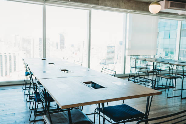 istock Detail of empty desktops against big windows in a modern office 1201710351
