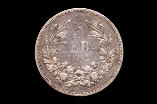 Old Bulgarian silver 5 leva coin from 1892, reverse. Isolated on black background