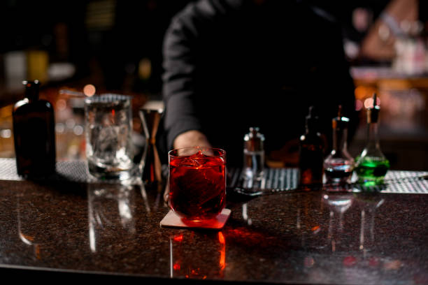 istock Professional male bartender serving the red alcoholic cocktail with ice cubes 1201711845