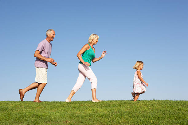 istock Grandparents with granddaughter running though field 120171276