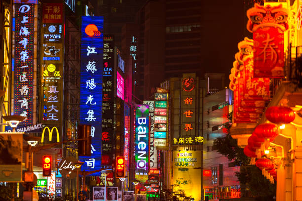 SHANGHAI, CHINA - FEBRUARY 18, 2018: Neon signs lit on Nanjing Road. The area is the main shopping district of Shanghai and one of the world's busiest shopping streets.