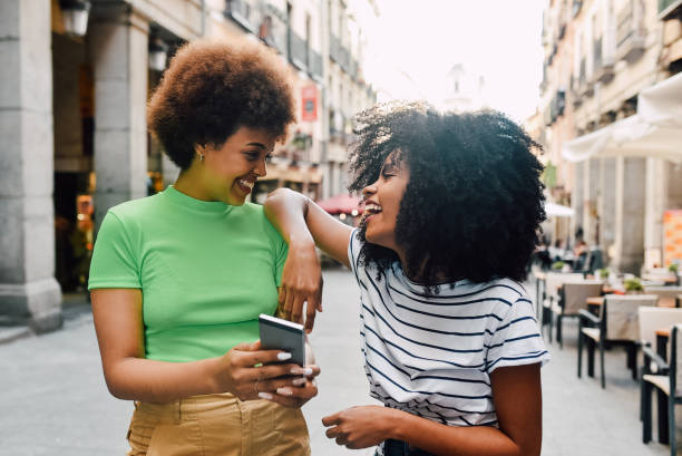 istock Two girls waiting for a taxi and using smartphone 1201713751