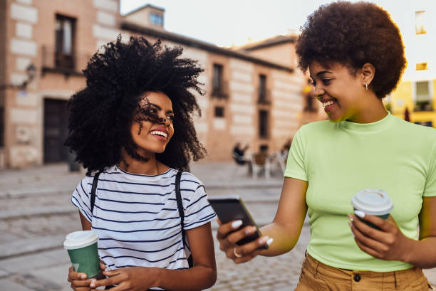 istock Two friends waiting for a taxi and using smartphone 1201713754