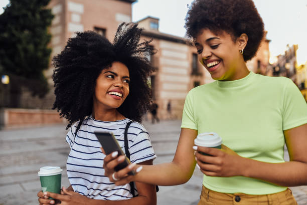 istock Two friends waiting for a taxi and using smartphone 1201713757