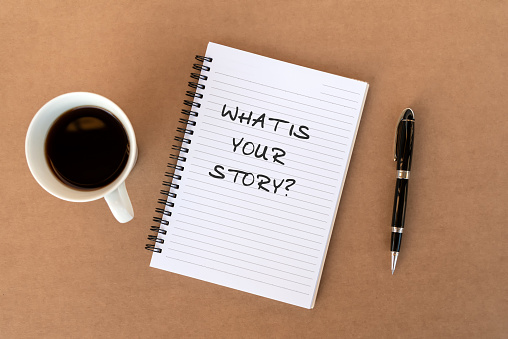 What is your story? text on note pad on top of wood desk