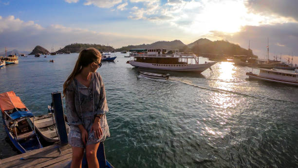 labuan bajo - una ragazza sul lungomare nel porto - flores man foto e immagini stock