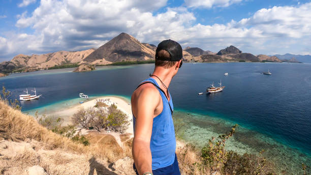 komodo - un uomo in piedi al tp dell'isola di kelor e guardando la baia - flores man foto e immagini stock