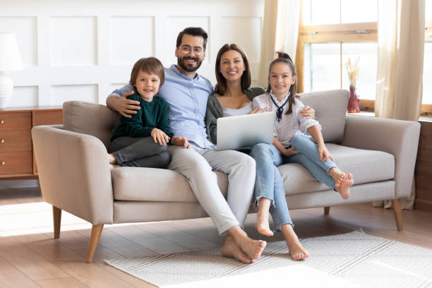 istock Happy young family sit on couch using modern laptop 1201716241