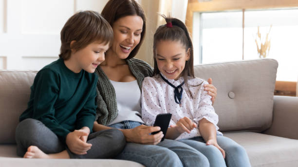 istock Happy mother and little kids have fun using cell 1201716244