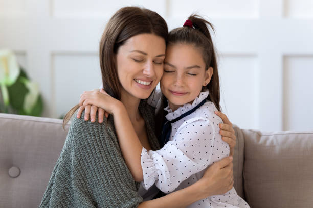istock Happy mum and small daughter relax on couch hugging 1201717111