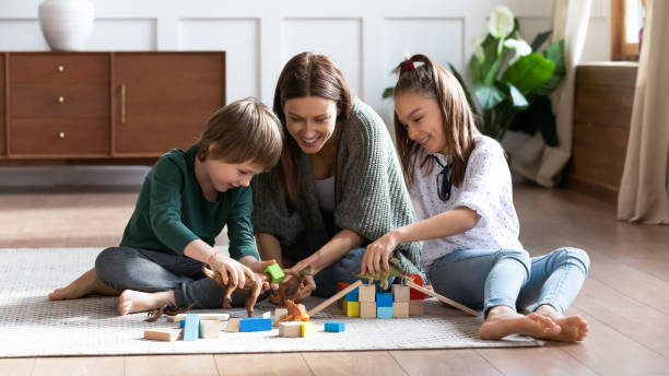 istock Loving mum sit on floor playing with little kids 1201717115