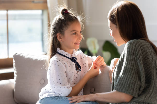 istock Loving young mom and little daughter share secrets on couch 1201717151