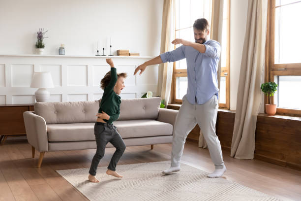 istock Happy young dad dancing jumping with little son 1201717162