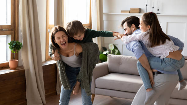 istock Overjoyed kids piggyback play with young parents 1201717165
