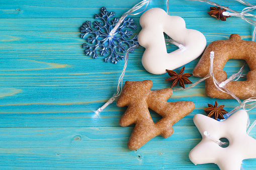 Gingerbread in the shape of a star, Christmas tree and house on a blue wooden background