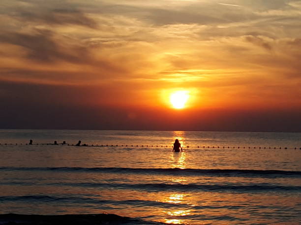 istock Sunset and silhouettes by the sea 1201719300