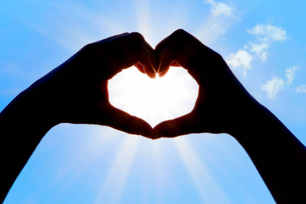 istock Hands forming a heart shape over the sun 1201721592