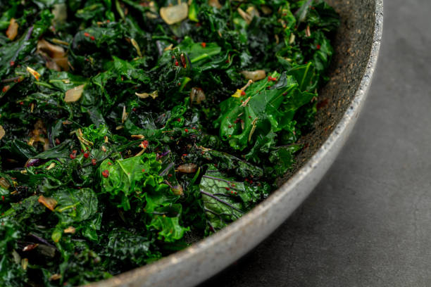 sauteed kale plant sauteed kale with onion in a pan with olive oil, healthy cooking concept sauteed stock pictures, royalty-free photos & images
