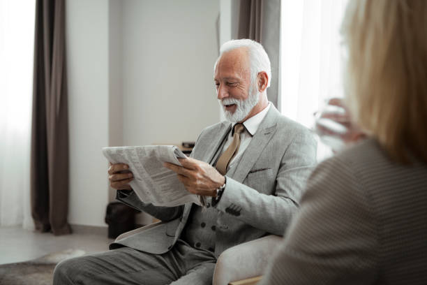 pareja de ancianos en una habitación leyendo periódico - hotel newspaper coffee reading fotografías e imágenes de stock