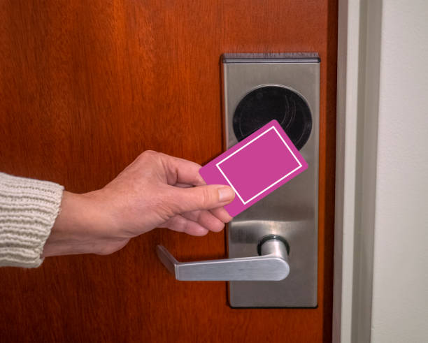 hand swiping key card to open hotel room door stock photo