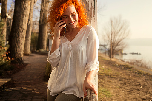 Happy woman outdoors talking on the phone