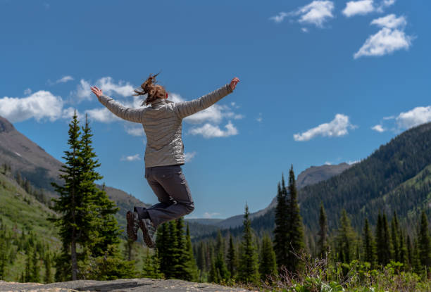 istock Woman Leaps with Joy on Sunny Montana Day 1201728998