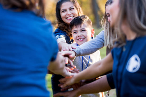 istock Multi-ethnic group of volunteers puts hands together for cheer 1201729958