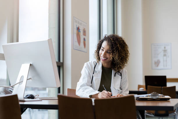istock Smiling female doctor makes notes for upcoming consultation 1201730023