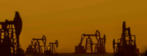 The silhouette of oil pumps in a large oil field at sunrise. 3d rendering. 3d illustration Sunset oil pump jack. The silhouette of oil pumps in a large oil field at sunrise. 3d rendering. 3d illustration crud stock pictures, royalty-free photos & images