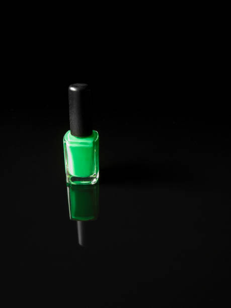 istock Green nail polish bottle on black background with refection 1201740084