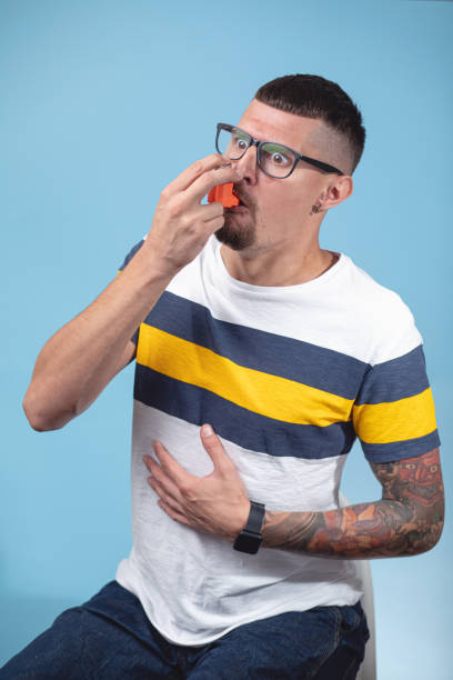 istock Struggling young man with a asthma inhaler 1201747881