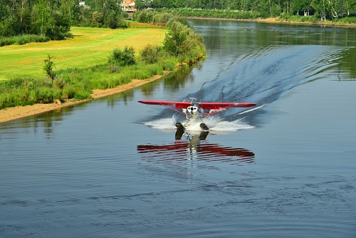 A red bush plane takes off from the Chena River near Fairbanks, Alaska.
