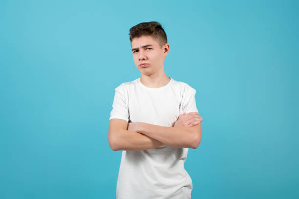 istock a young man folded his arms over his chest and shows doubt on his face 1201754762