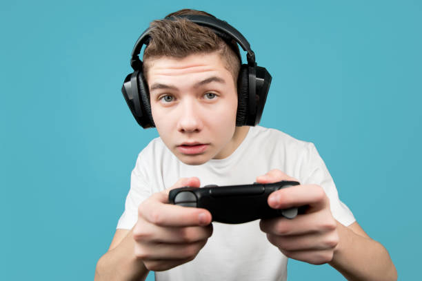 istock a schoolboy in headphones with a joystick from a game console in his hands 1201754914