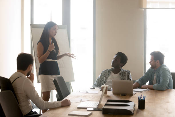 istock Asian coach making presentation for diverse company staff 1201756562