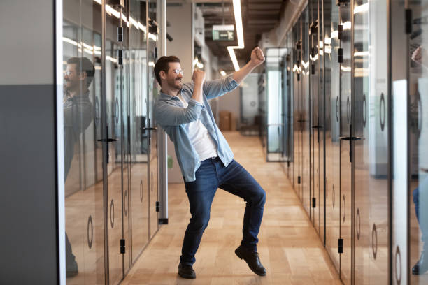 en el pasillo de la oficina trabajador de baile consiguió promoción celebrando el éxito empresarial - perks fotografías e imágenes de stock