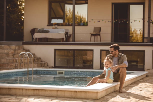 istock Father and daughter having fun while relaxing at the swimming pool in their back yard 1201756709
