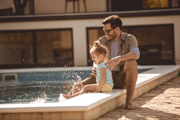 istock Splashing the water in the swimming pool and having fun 1201756713
