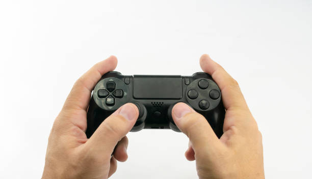 istock Hands of a man playing with a black game controller with keypad and buttons 1201759696