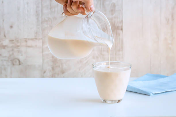 istock Fermented baked milk is poured from a jug in a glass. 1201762984