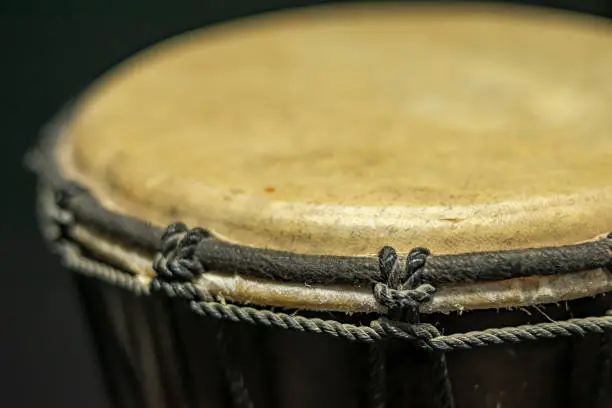 Close-up of a djembe of natural skin of African origin with its tightly fastened tension and tuning strings