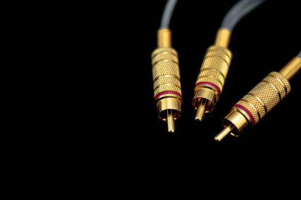 Three golden rca male connectors, with red stripe, over black background