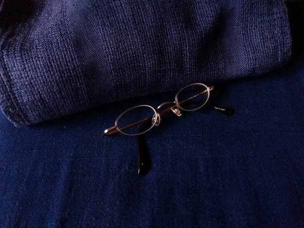 istock brown glasses with indigo pillow and bed sheet 1201770679