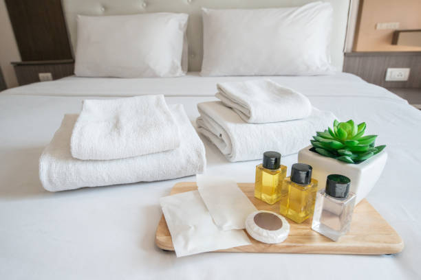 istock Set of hotel amenities (such as towels, shampoo, soap, gel etc) on the bed. 1201775880
