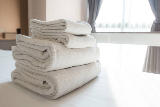 istock Stack of soft towel on the bed in comfortable hotel bedroom. 1201775881