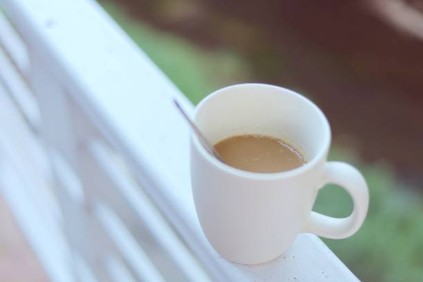 istock White coffee cup against blurred natural green background for drinks and beverage concept 1201779644